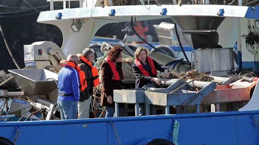 La conselleira Rosa Quintana (derecha) y la directora xeral comprueban el encordado de la mejilla.