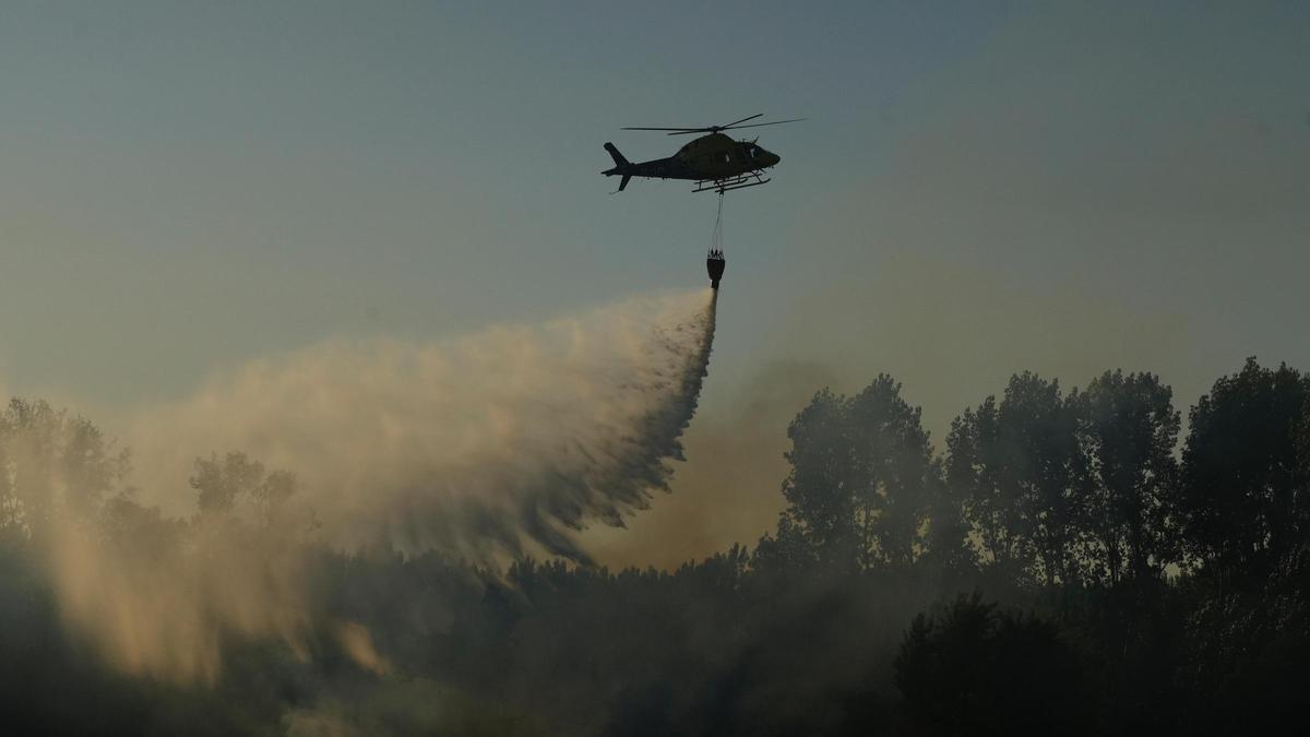 Un helicóptero trabaja en las labores de extinción del fuego en Villaralbo.