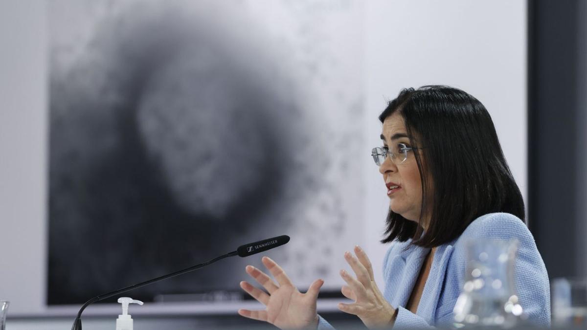 La ministra Darias con una imagen microscópica del virus de la viruela del ISCIII en segundo plano.