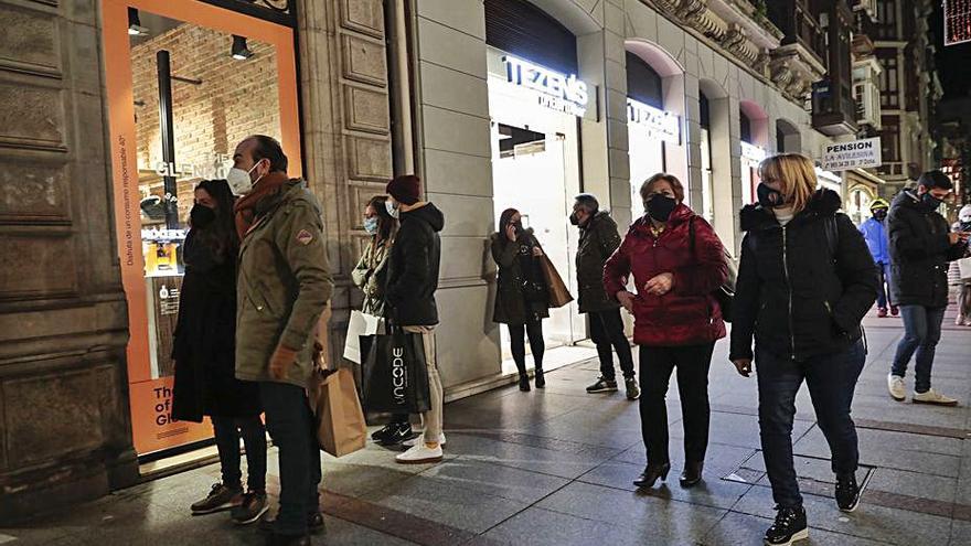 Clientes haciendo cola frente a una tienda en la calle Corrida de Gijón. | M. L.