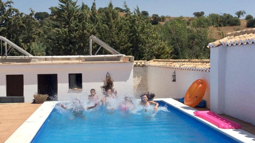 Diversión en familia. Los jóvenes disfrutan de una tarde de piscina junto con sus familiares en una casa de campo ubicada en plena naturaleza.