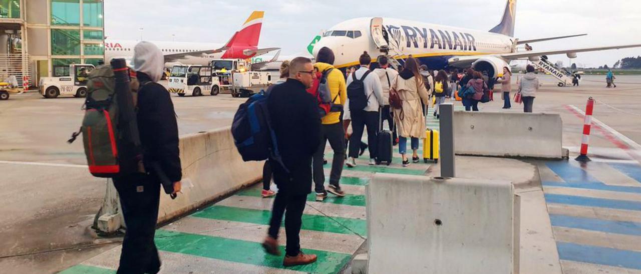 Viajeros ante los aviones de Iberia y Ryanair en el aeropuerto  de Oporto el pasado año.