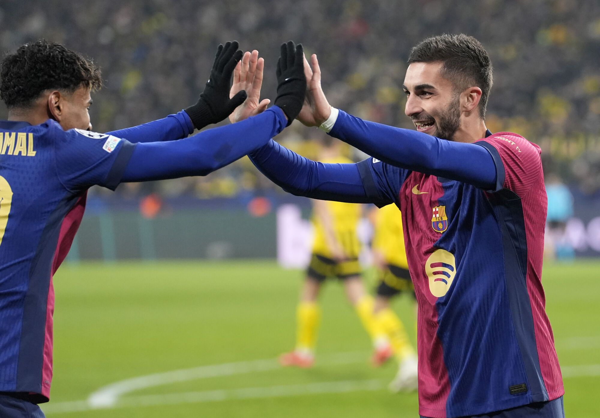 Barcelona's Ferran Torres celebrates his side's second goal with Barcelona's Lamine Yamal during the Champions League opening phase soccer match between Borussia Dortmund and FC Barcelona at the Signal-Iduna Park in Dortmund, Germany, Wednesday Dec. 11, 2024. (AP Photo/Martin Meissner)