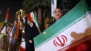 Un grupo de manifestantes sostienen banderas iraníes y palestinas durante una manifestación antiisraelí después de que Irán lanzara ataques con drones contra Israel en la Plaza Palestina de Teherán.