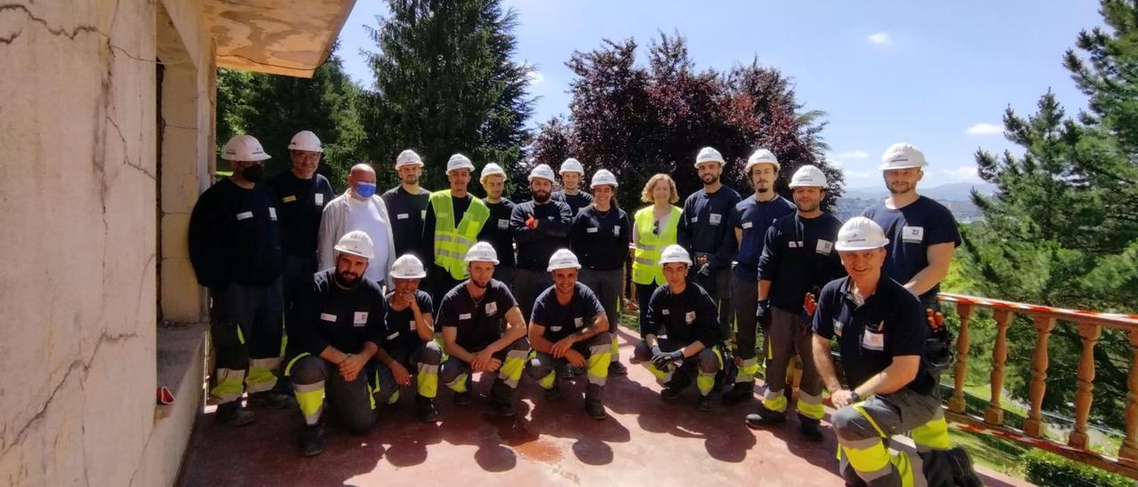 Parte de los alumnos del taller posan en la terraza del chalé con sus monitores Antonio Méndez y Fernando García, primero y segundo por la izquierda; el director, Ismael Fernández, tercero; la maestra, Azucena García, en el centro, con chaleco amarillo, y Enrique Fernández, monitor, a la derecha.   J. N.