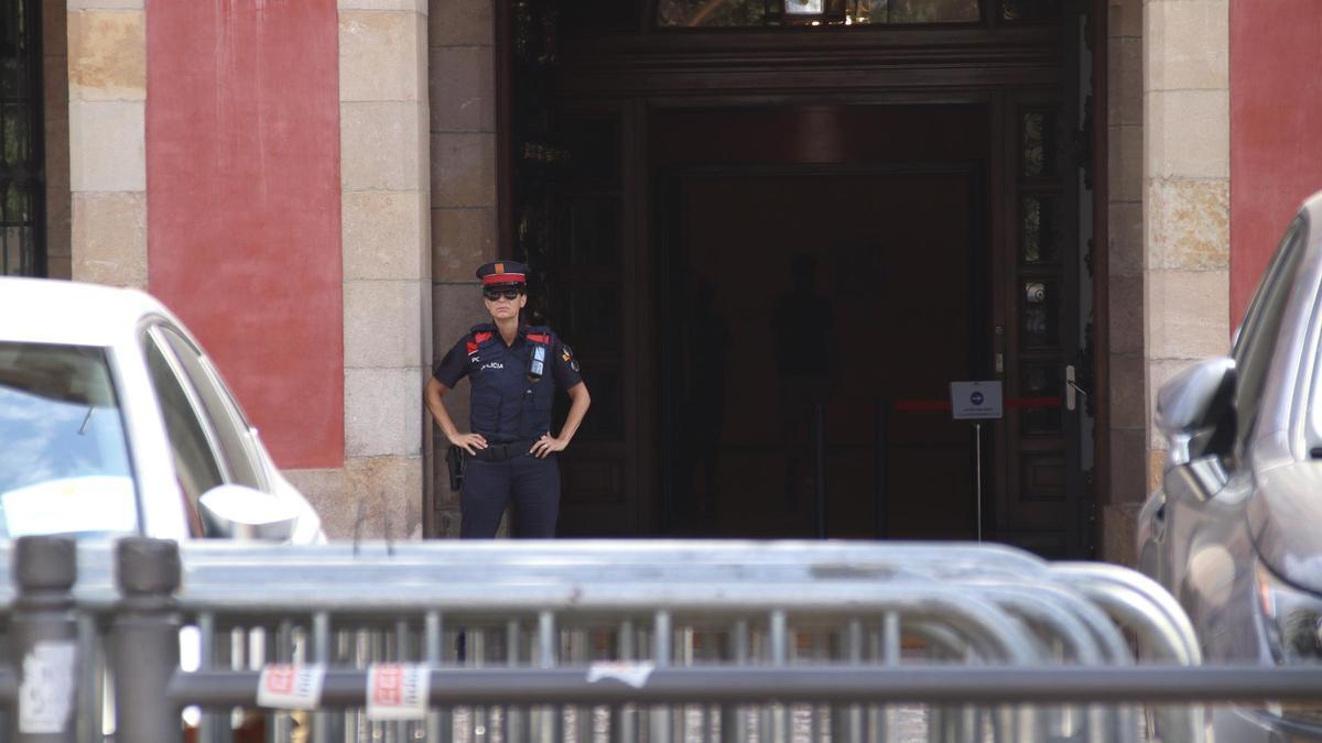 Una agente de los Mossos d'Esquadra a las puertas del Parlament, con vallas preparadas para blindar los accesos.