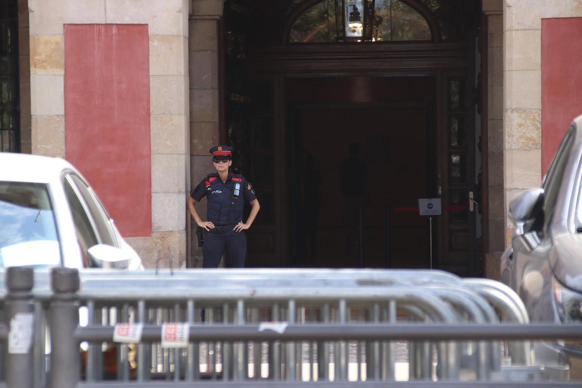 Una agente de los Mossos dEsquadra a las puertas del Parlament, con vallas preparadas para blindar los accesos.