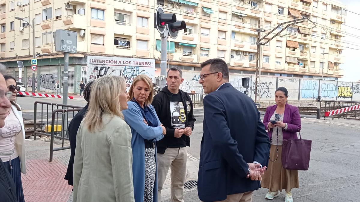 Susana Camarero y Juan Ramón Adsuara hablan con la plataforma vecinal junto al paso a nivel.