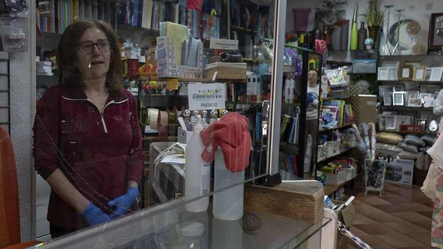 Alejandra Araujo tras la mampara de cristal que ha instalado en el mostrador de la tienda y librería para evitar el contagio del virus.