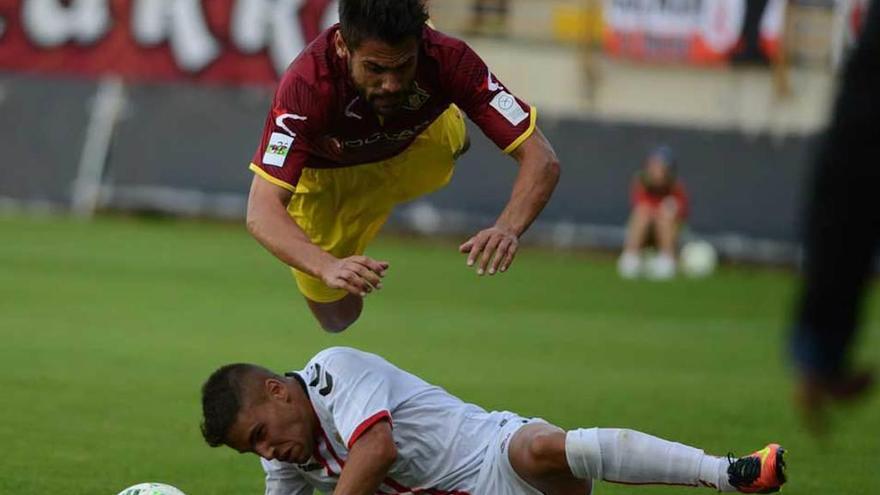 Noel Alonso salta por encima de un jugador de la Cultural en el duelo de la primera vuelta en León.