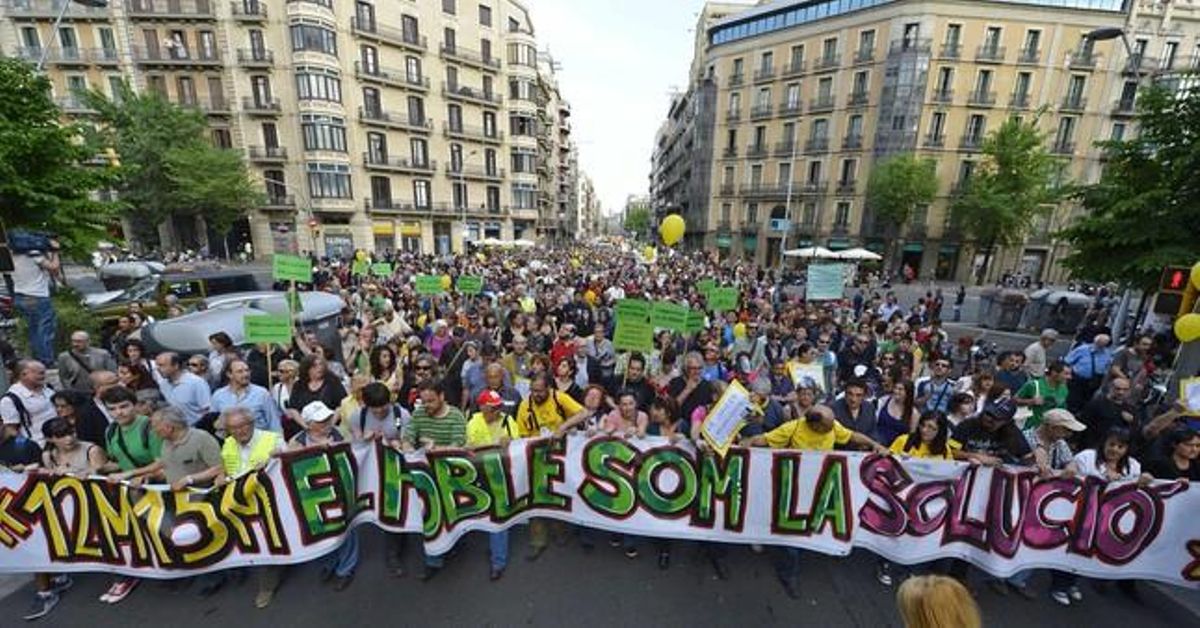 La pancarta que va encapçalar la manifestació multitudinària pel centre de Barcelona portava com a lema 12M-15M. El poble som la solució.