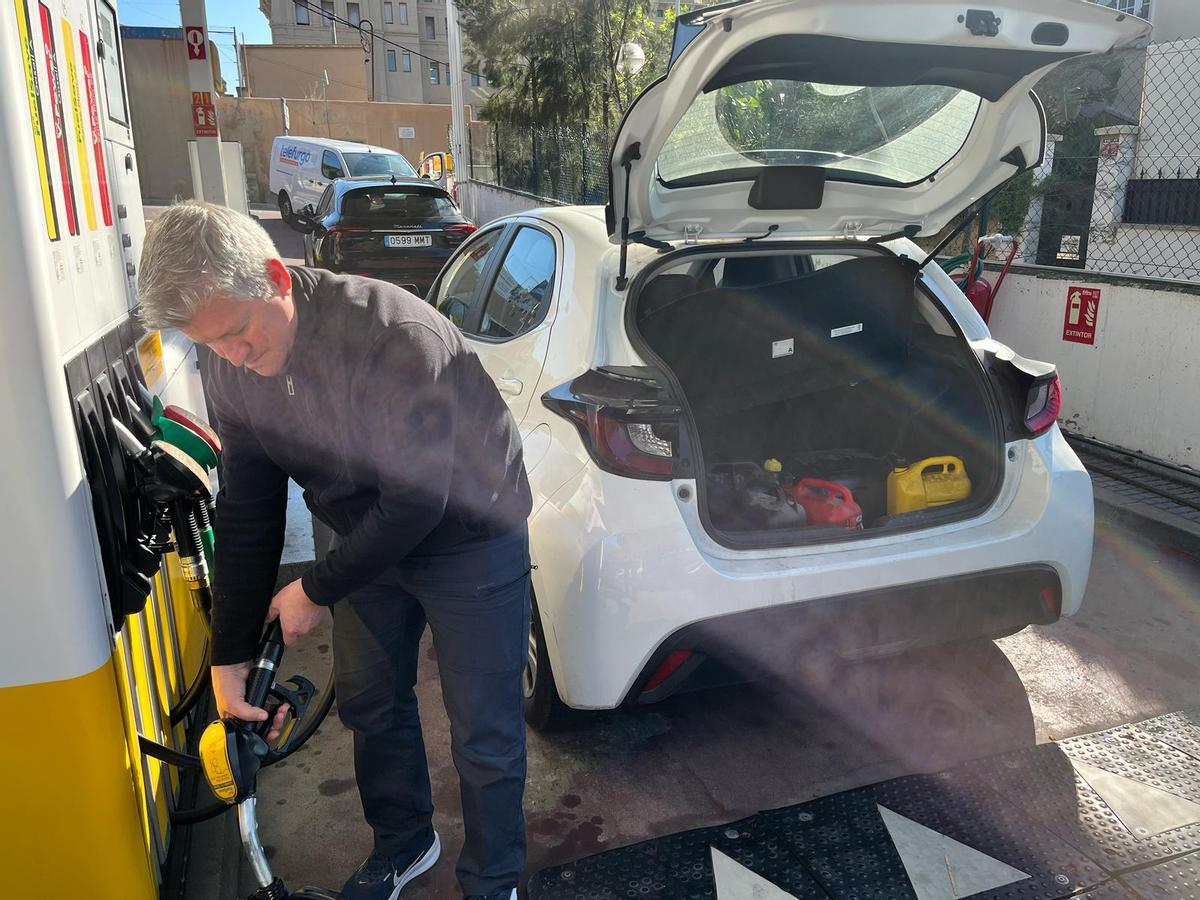 Un hombre llena depósitos de gasoil para el generador de la casa en la que trabaja.
