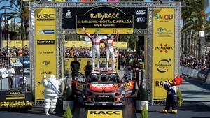 Kris Meeke (derecha) y su copiloto Paul Nagle celebran el triunfo en el Rally de Catalunya sobre el capó de su Citroën.