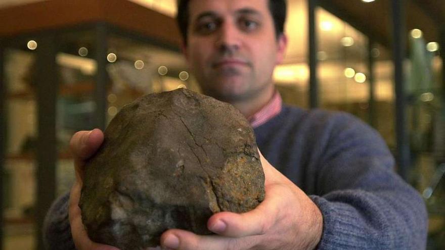 Luis Rodríguez Terente muestra un fragmento del meteorito que cayó sobre Cangas en 1866.