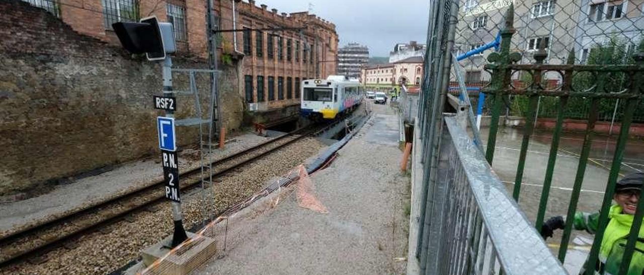 El tren circula por las inmediaciones del barrio Urquijo, en La Felguera.