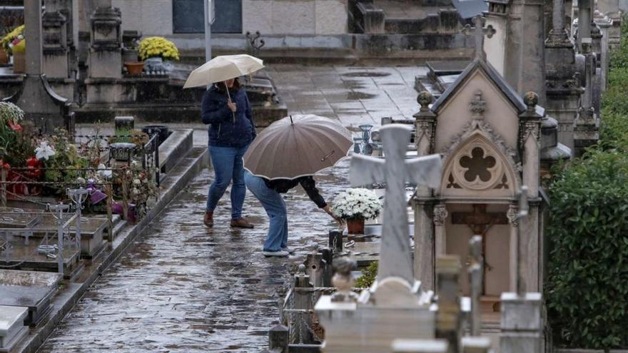 Algunas personas han adelantado su visita al cementerio pese a la lluvia.