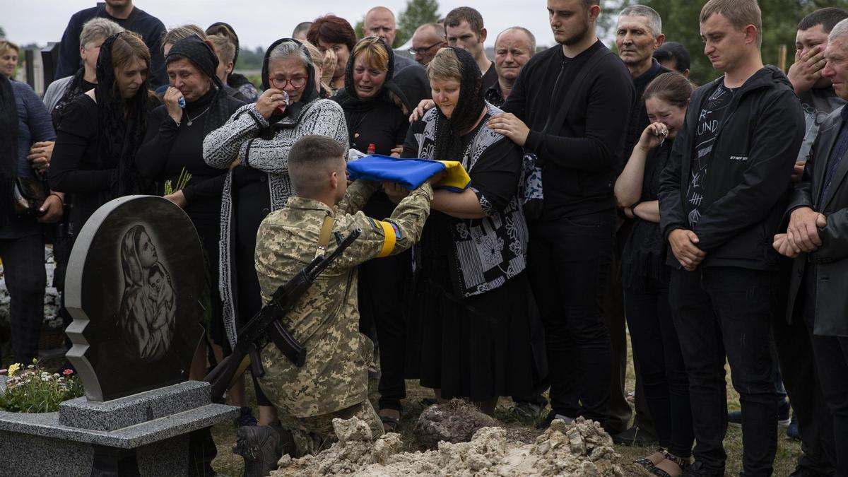 Un soldat entrega la bandera ucraïnesa a la mare d&#039;un company mort durant la defensa de Severodonetsk.
