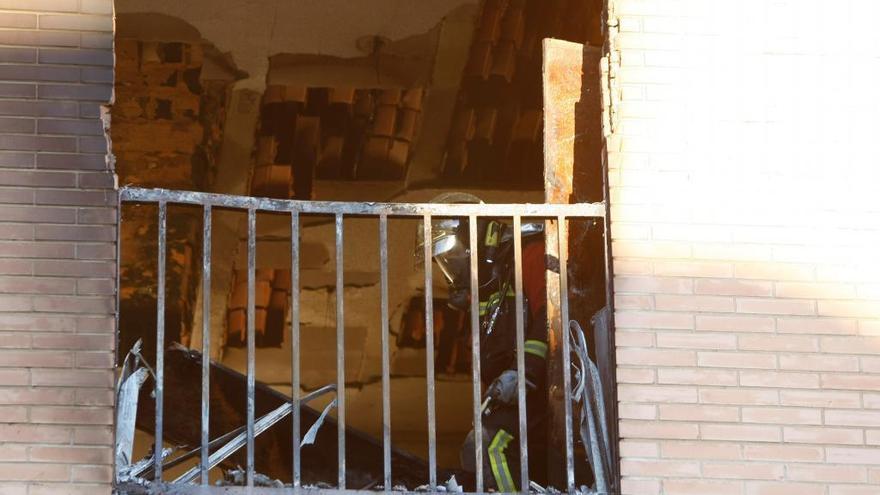 Un bombero, en el interior de la vivienda destrozada por el fuego.