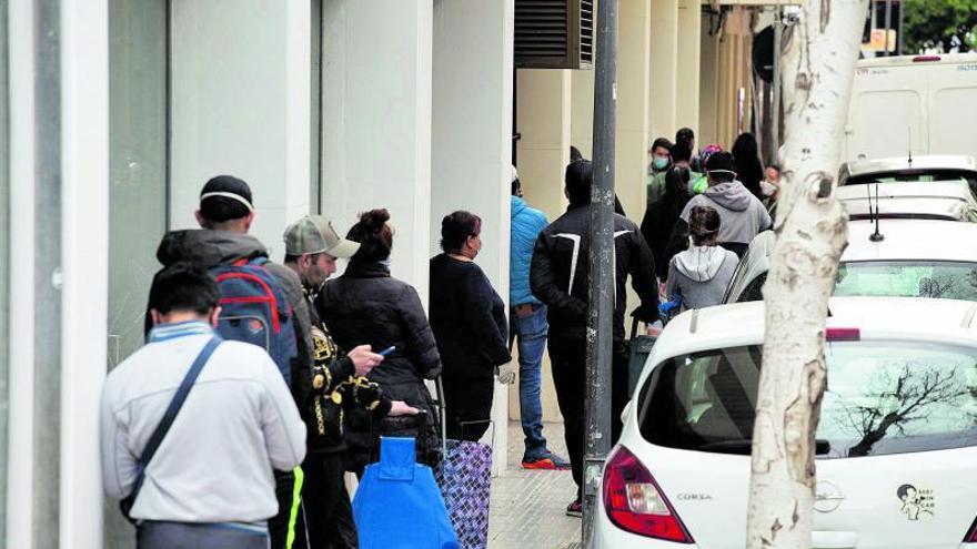 Aparecen las colas del hambre: decenas de personas esperan para recibir, el 15 de abril, los lotes de comida que distribuye Cáritas.
