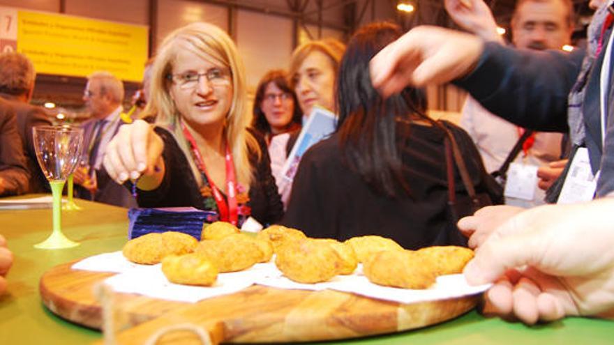 Una asistente al estand de Ibiza se lanza a por una croqueta de ´bullit de peix´.