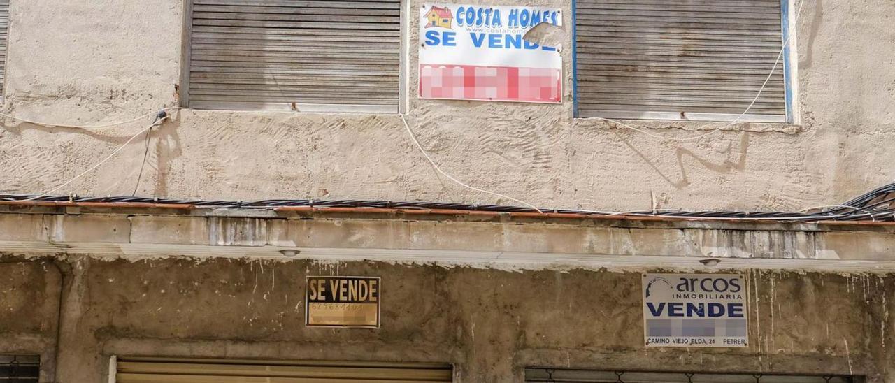 Un edificio con varios carteles de «se vende», en Elda.