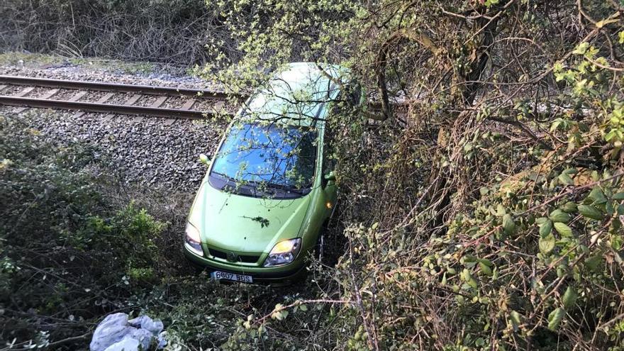 Olvida poner el freno de mano y su coche se despeña a las vías del tren