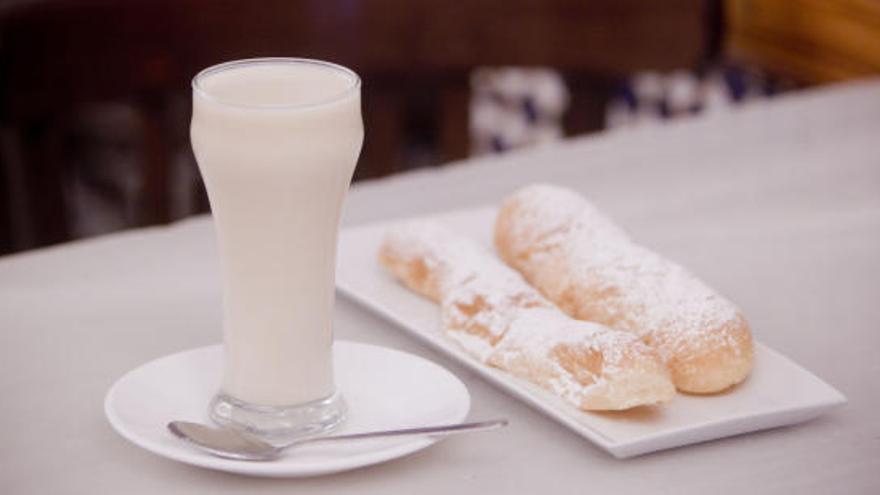 Un vaso de horchata con dos fartons