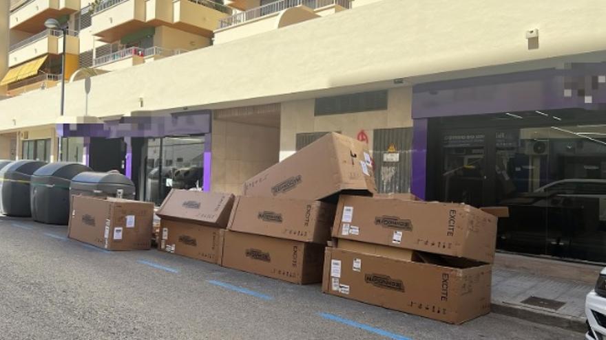 Varias plazas de parking de Ibiza, ocupadas por cajas de material deportivo frente a un gimnasio