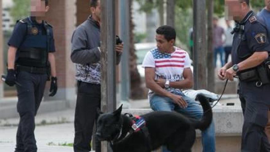 A la izquierda, dos policías someten a un cacheo a un hombre durante el despliegue. A la derecha, policías con perros identifican a otro ciudadano.