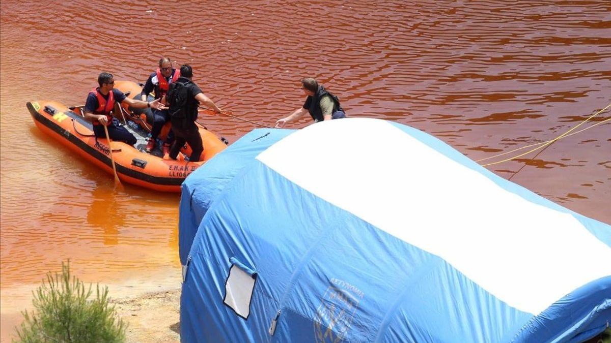 Miembros de los servicios de rescate navegan por el Lago Rojo mientras buscan nuevas pistas de los crímenes.