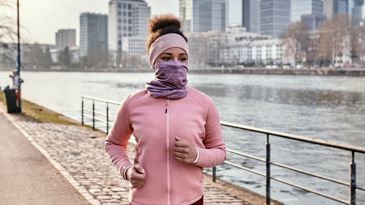 Una chica corriendo con un Buff y una diadema térmica.