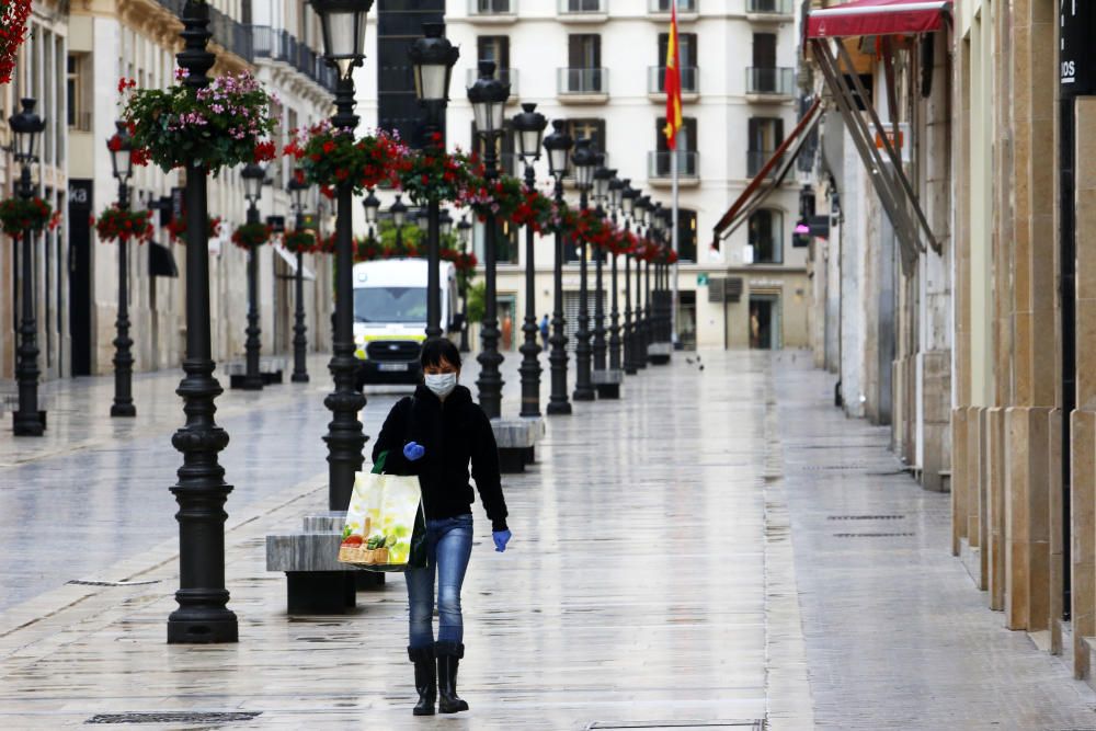 Pasan los días de confinamiento y la situación de la ciudad sigue siendo desértica. La siempre frecuentada calle Larios, la Alameda, principal vía de tráfico tanto privado como público del centro de la ciudad, y el bullicioso mercado de Atarazanas presentan durante el estado de alarma provocado por la pandemia de coronavirus una imagen inusual, acentuada por la persistente lluvia de esta semana.