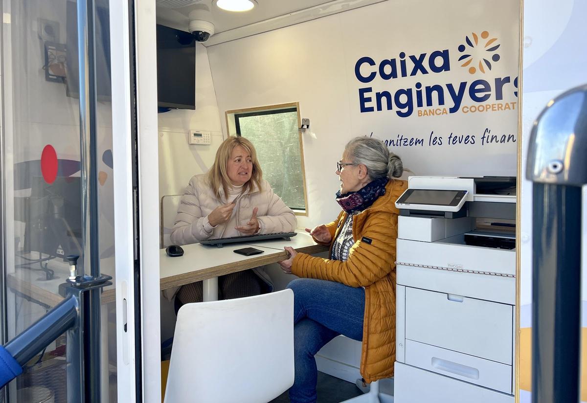 Una clienta és atesa a l'oficina mòbil de Caixa d'Enginyers abans de retirar efectiu