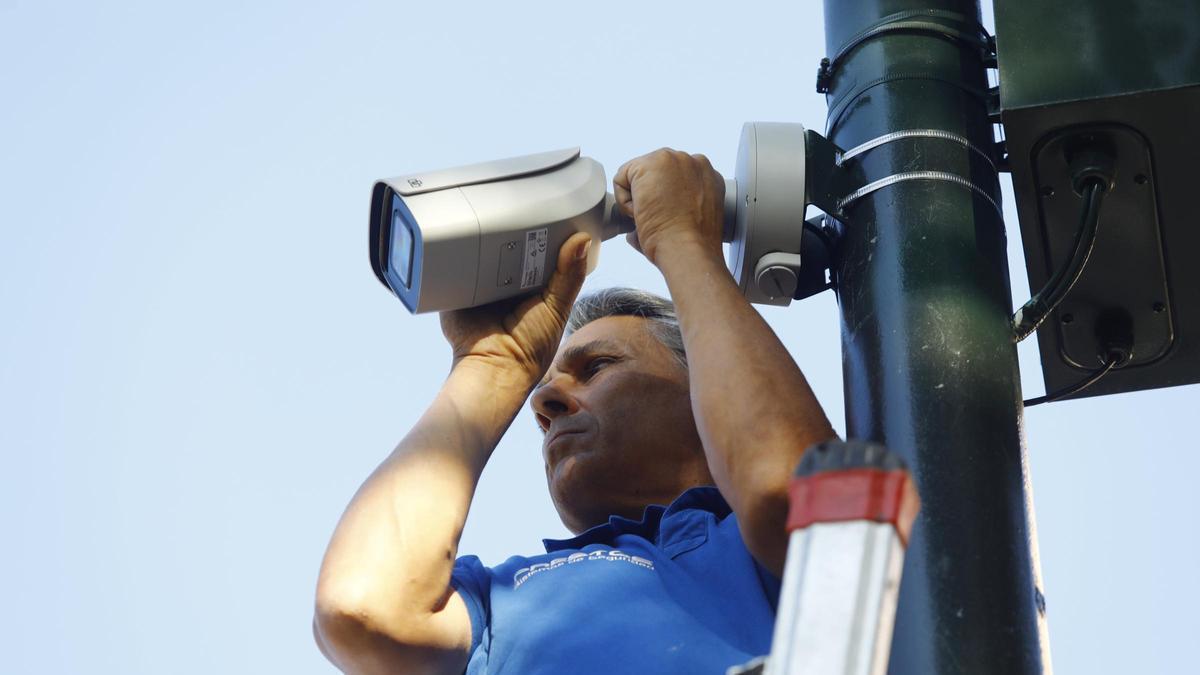 Un técnico instalando una cámara de videovigilancia en una imagen de archivo.