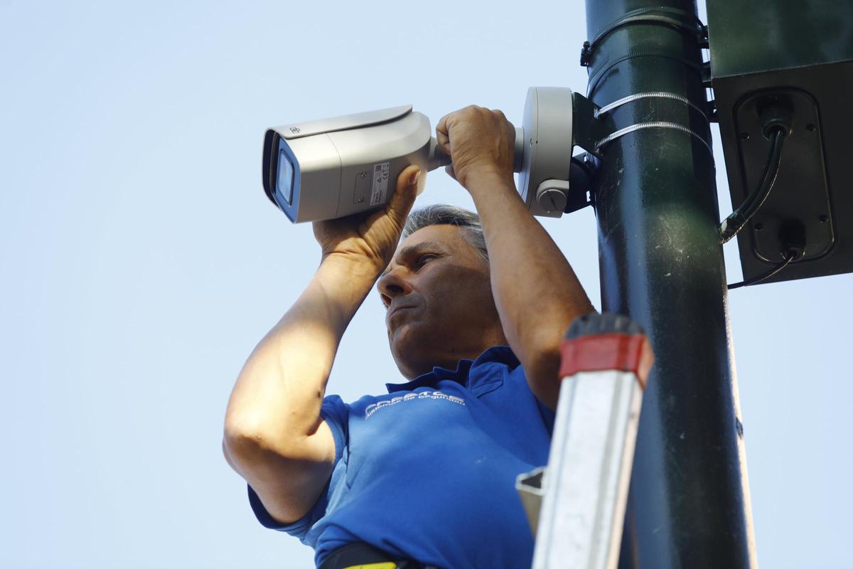 Un técnico instalando una cámara de videovigilancia en una imagen de archivo.