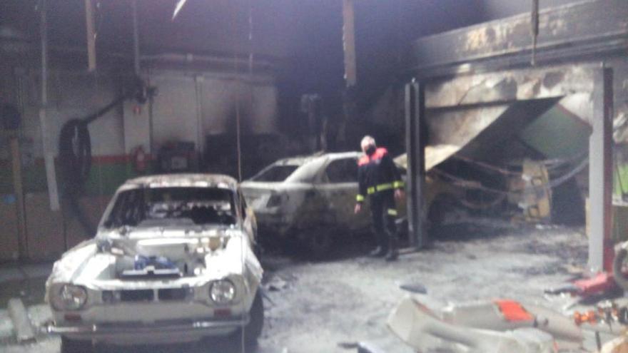 Un bombero examina el taller incendiado tras haber sofocado las llamas. // Faro