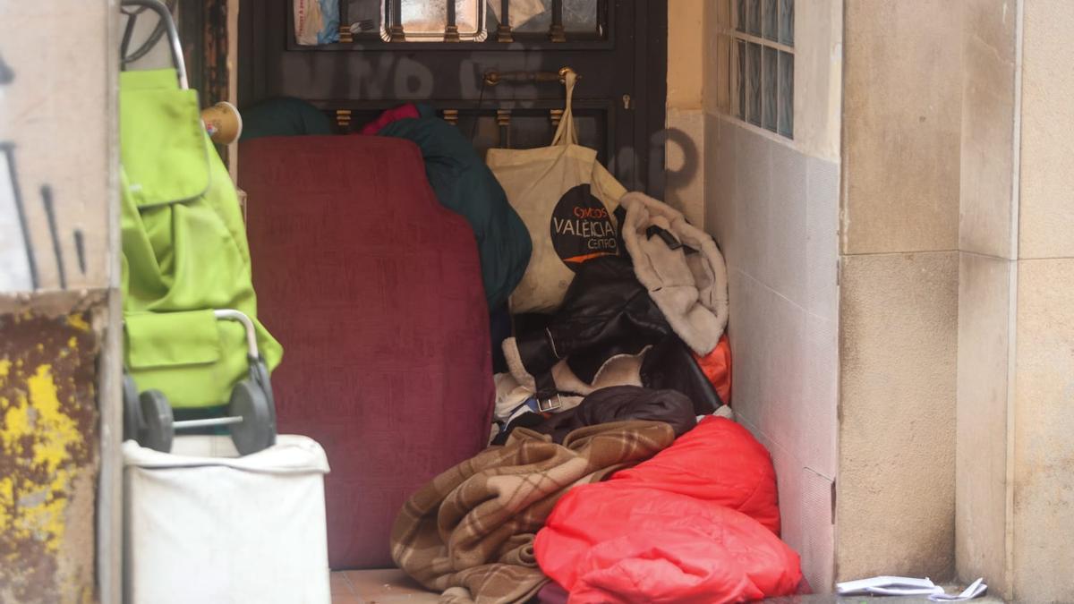 Un sintecho con su campamento en un portal