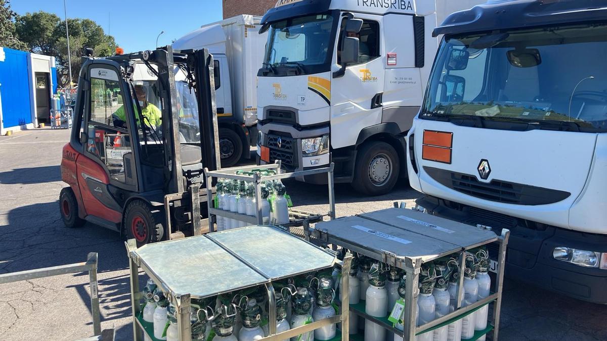 Operarios cargan botellas de oxígeno para repartir entre los pacientes.