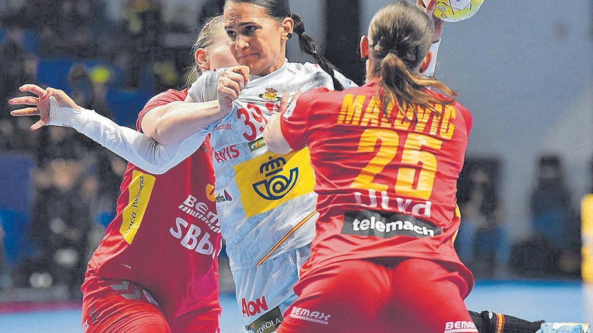 La grancanaria Almudena Rodríguez intenta el lanzamiento sujetada por dos rivales, en el duelo de ayer en Montenegro. | | EFE