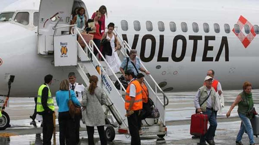 Pasajeros del avión de Volotea procedente de Ibiza a su llegada ayer a Peinador; media hora después partía a Sevilla.  // Jesús de Arcos