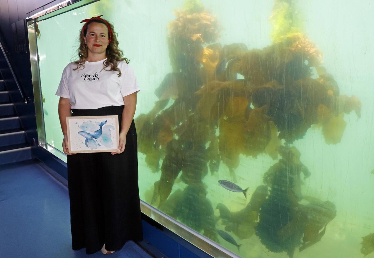 Eva Casais mostrando una acuarela marina en el visor submarino.