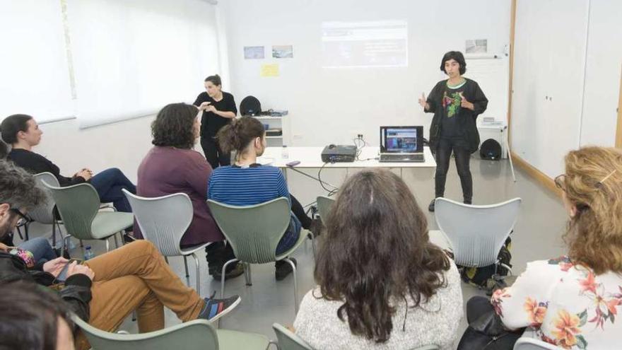 Claudia Delso, de pie, explica a vecinos de Mesoiro cómo se elaboran los presupuestos participativos.