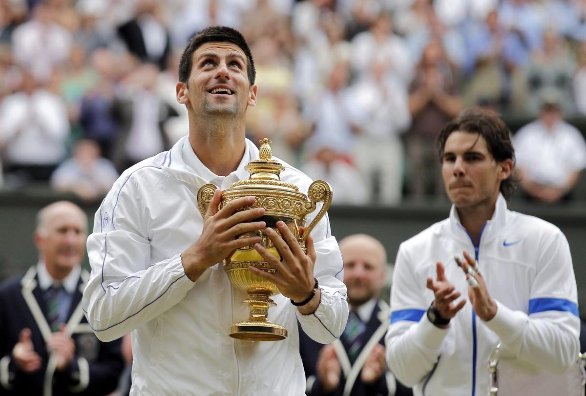 Novak Djokovic sostiene su trofeo de campeón tras ganar a Rafael Nadal en la final de Wimbledon 2011