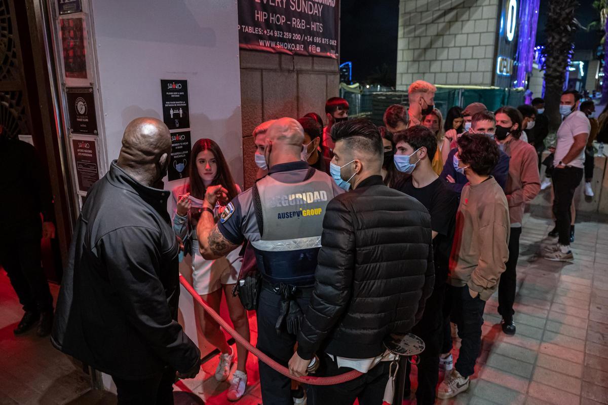 Jóvenes entran a una discoteca del Paseo Marítimo de Barcelona poco después de que se permitiera abrir los locales de ocio tras el confinamiento.