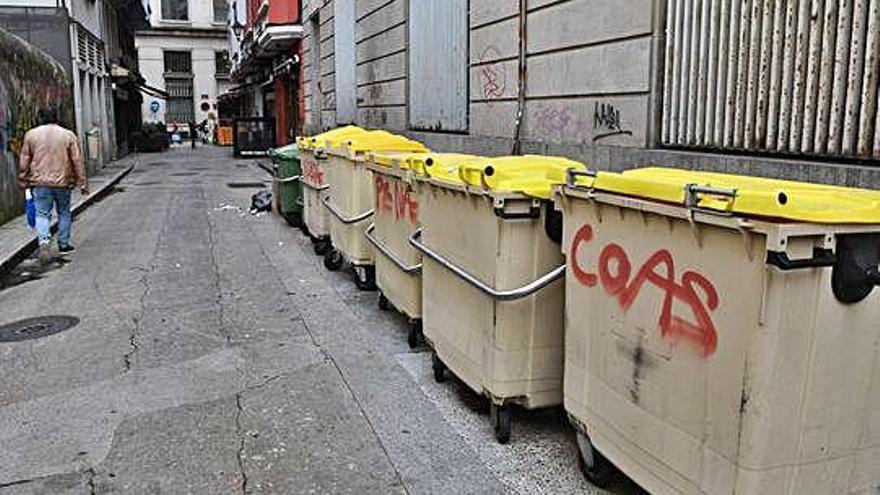 Un contenedor con el mensaje &#039;COAS&#039; pintado en la calle Mantelería.