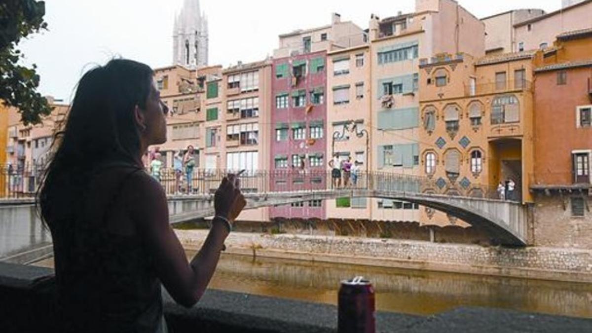 Una joven fuma en una calle de Girona, ayer.