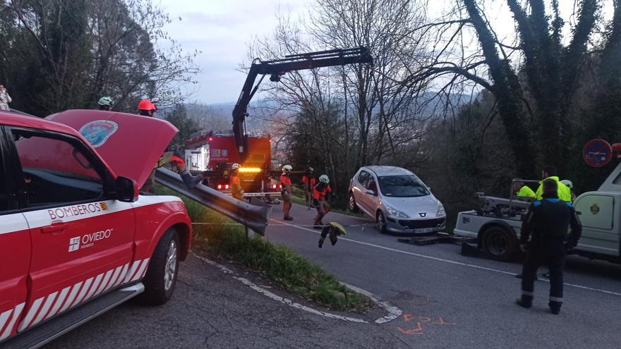Espectacular rescate en Oviedo de un coche que quedó con dos ruedas en el aire junto a San Miguel de Lillo