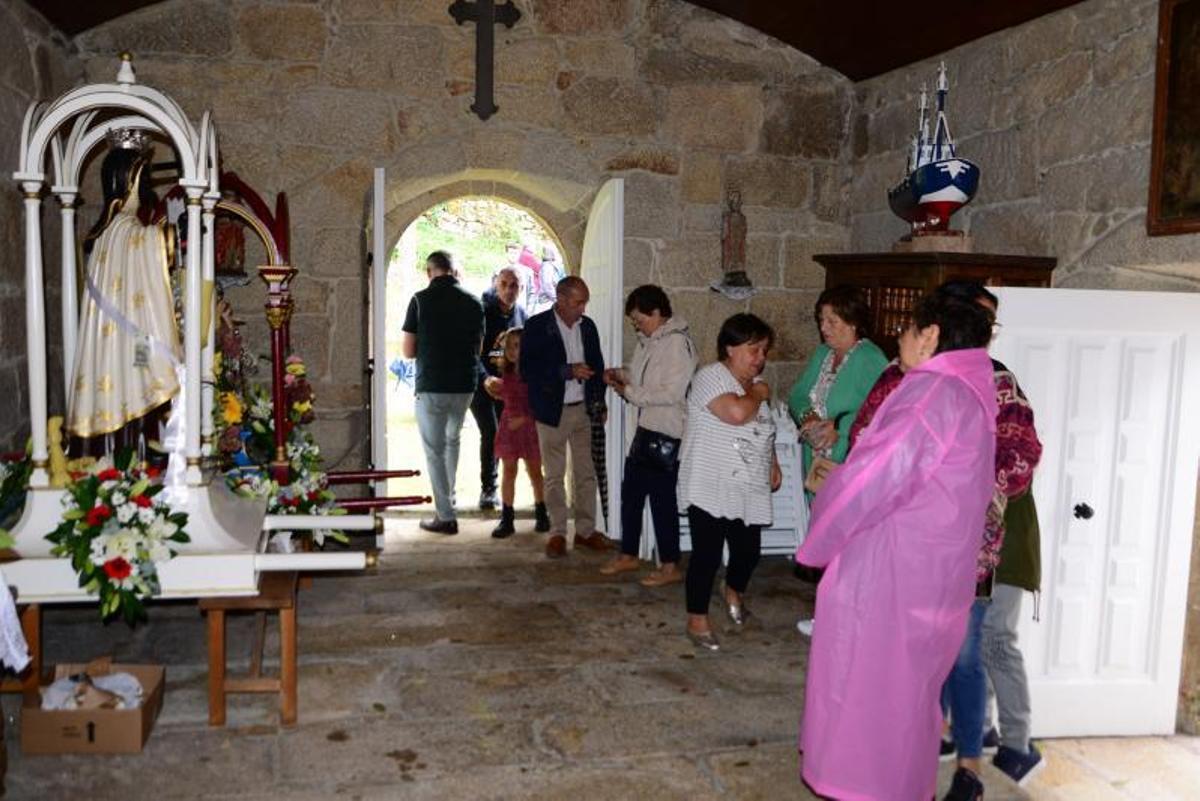 Varias personas en el interior de la capilla, con la imagen de Santa Ifigenia.   | //G.NÚÑEZ