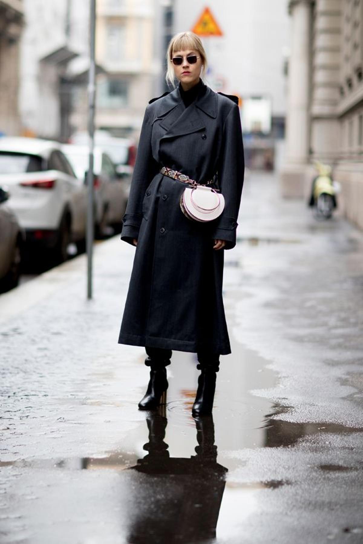 Riñonera blanca con banda estampada sobre un abrigo cruzado en el 'street style' de Milán