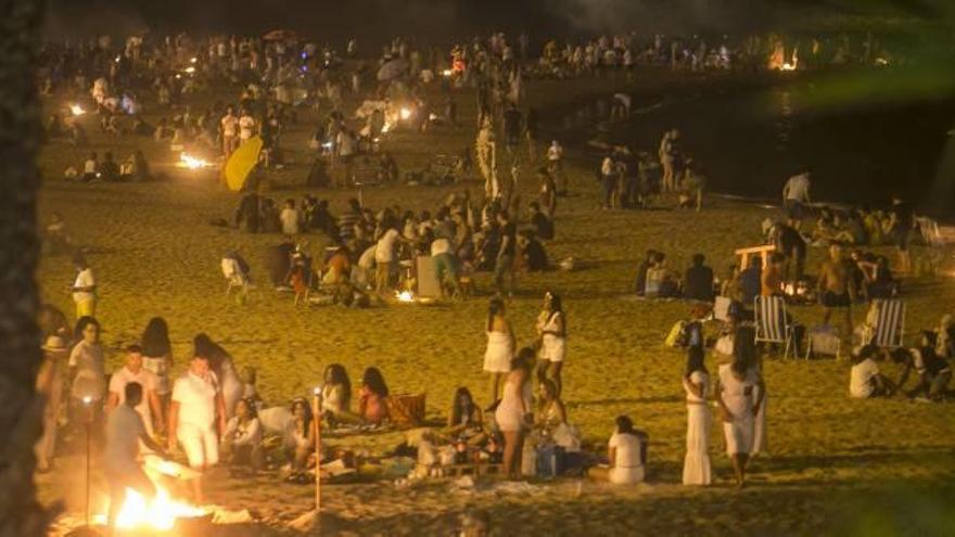 Decenas de alicantinos cumplieron con la tradición de la noche de San Juan de saltar hogueras en la playa. El Postiguet, anoche.